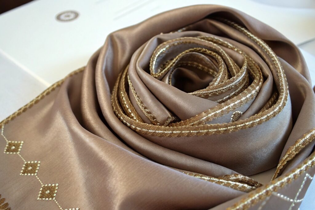 A woman wearing a large, chunky knit brown scarf