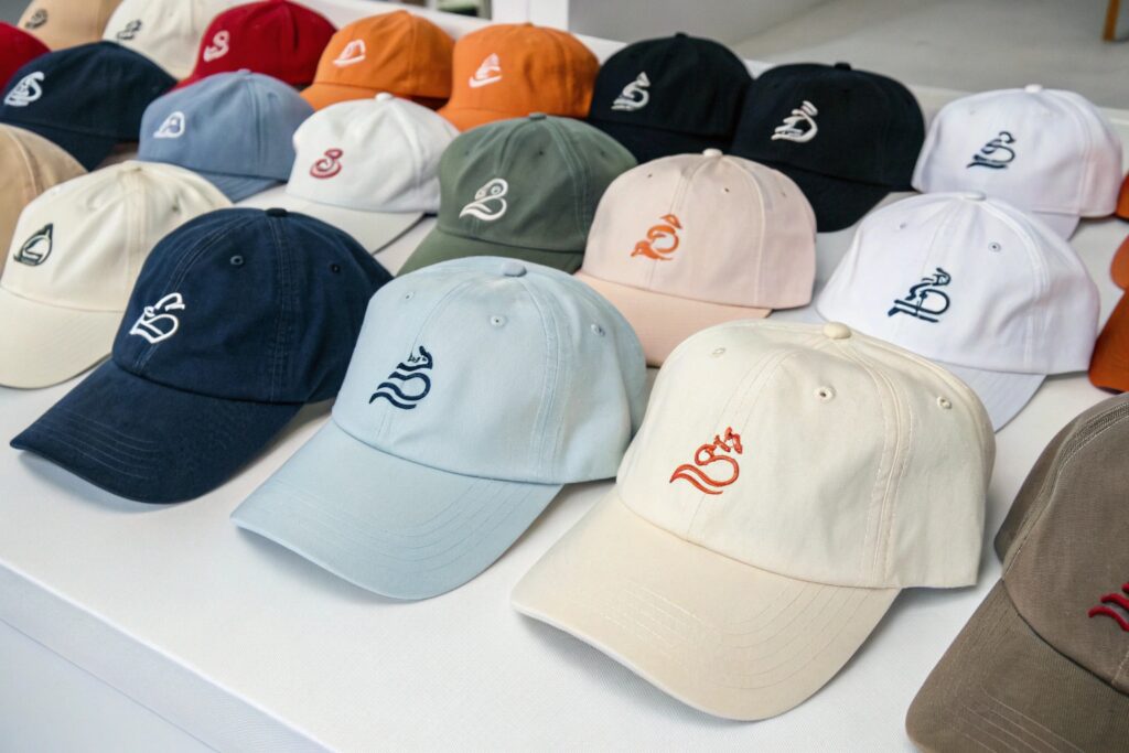 A variety of colorful caps with a logo