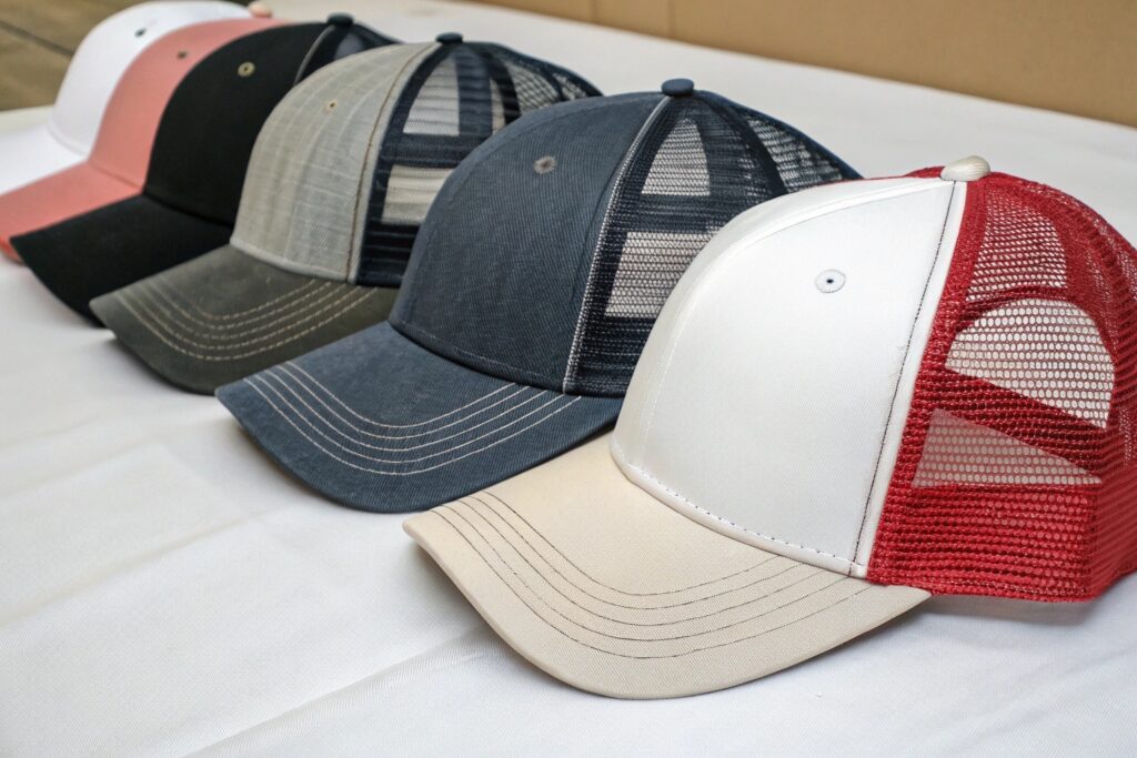 A close-up of an embroidery machine working on a baseball cap
