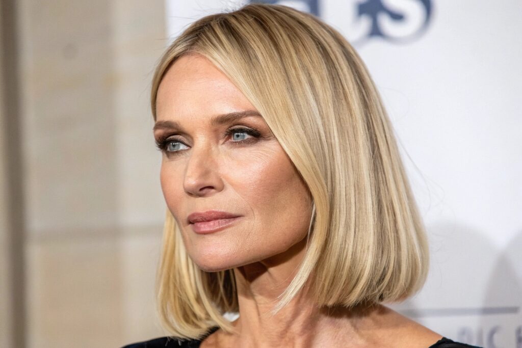A person with shoulder-length blonde hair looking slightly to the left