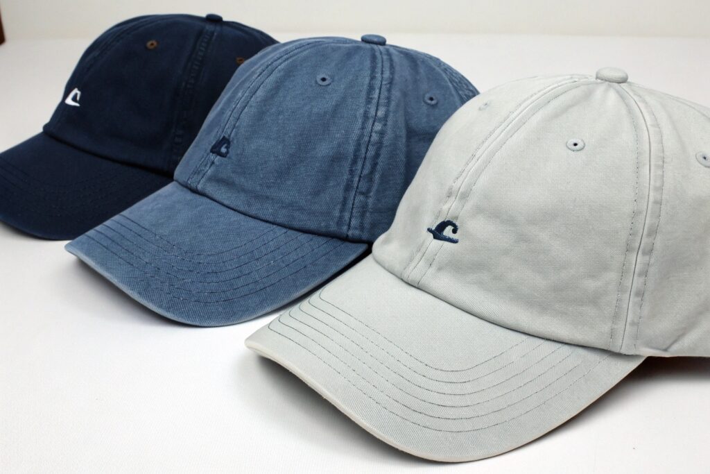 A box full of black baseball caps, one with a "FREE SHIPPING" label