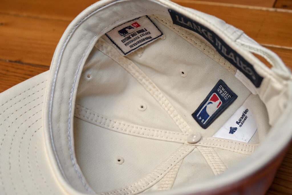 A split image showing baseball caps on boxes and a person browsing a hat website on a computer